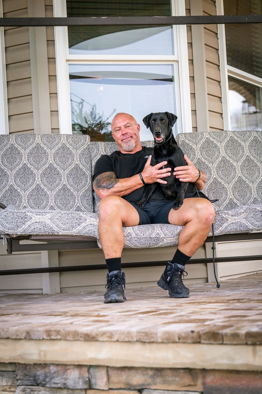 Black dog during behavior training on a porch